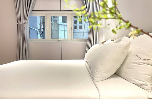 Nguyen Hue Walking Street Apartment | The Cafe Apartments building - Deluxe King room has a large window and a 70" TV