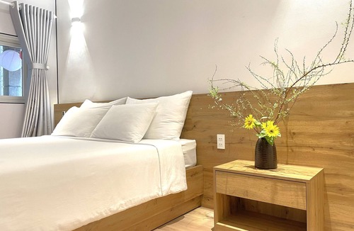 Nguyen Hue Walking Street Apartment | The Cafe Apartments building - Deluxe King room has a large window and a 70" TV