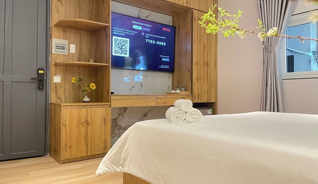 The Cafe Apartments building - Deluxe King room has a large window and a 70" TV